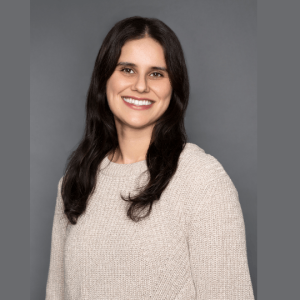 Ksenia Mack, PT, DPT at Lakeshore Physical Therapy, wearing a flesh knitted top, smiling at the camera.