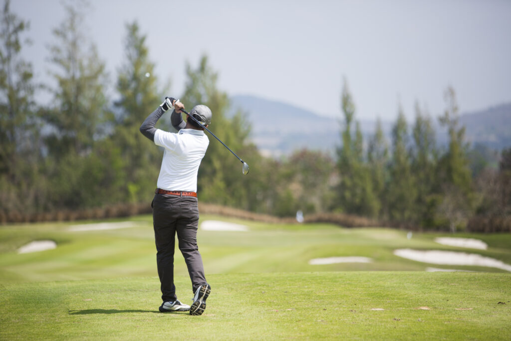 Golfer practicing his swing on a golf course to improve mobility and prevent golf-related injuries.