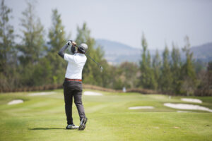 Golfer practicing his swing on a golf course to improve mobility and prevent golf-related injuries.